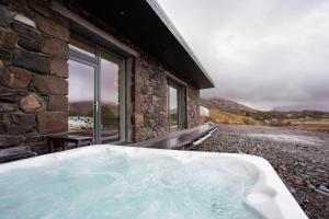 a bath tub sitting next to a stone building at Three Lochs View, Ardelve, by Dornie in Dornie