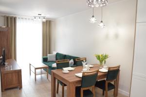 - une salle à manger avec une table et un canapé dans l'établissement Apartament Luna Baltic Marina Residence, à Kołobrzeg