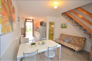 una cucina e un soggiorno con tavolo e sedie di Green Holiday Village with Pool a Bibione