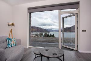 a living room with a couch and a large window at Three Lochs View, Ardelve, by Dornie in Dornie