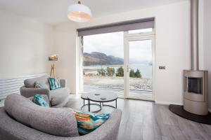 un soggiorno con 2 sedie e una TV di Three Lochs View, Ardelve, by Dornie a Dornie Altre 4 foto