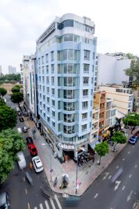 duży biały budynek przy ulicy miejskiej z samochodami w obiekcie Calista Sai Gon Hotel w Ho Chi Minh