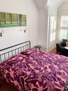 a bed in a bedroom with a purple blanket at Derrin Guest House in Larne