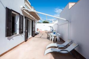 un balcone con sedie e tavolo su un edificio di Casa Rebecca a Torre San Giovanni Ugento