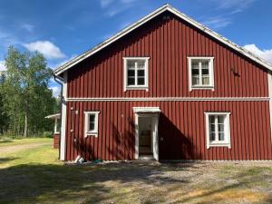 a red barn with a white door and windows at Linsell nyrenoverad lägenhet in Linsell