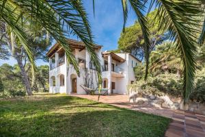 una vista exterior de una casa con palmeras en Tamariu Montagut Domain, en Palafrugell