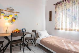 a bedroom with a bed and a desk and a table at Blossom in Ierapetra