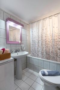 a bathroom with a sink and a shower curtain at Blossom in Ierapetra