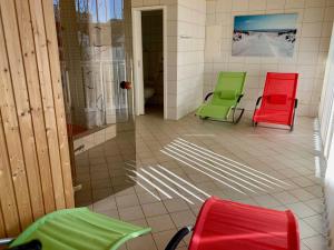 two green and red chairs in a room at Ferienwohnung mit Meerblick und Sauna in Göhren