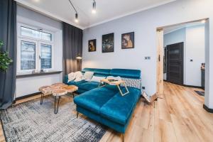 sala de estar con sofá azul y mesa en Zender Kazimierz Apartment, en Cracovia
