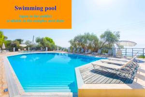 ein Schwimmbad, das für die öffentliche Münze in der fertigen Arbeit geöffnet ist in der Unterkunft Nissaki Apartments and Vasilis House in Nisaki