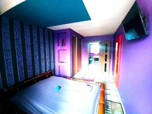 a room with a bed in a room with purple walls at Nastrojowe Mieszkanie Plac Krakowski Gliwice 60m2 in Gliwice