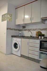 eine weiße Küche mit Waschmaschine in der Unterkunft Alojamiento Santa Maria II in O Milladoiro