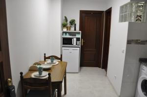małą kuchnię ze stołem i kuchenką mikrofalową w obiekcie Alojamiento Santa Maria II w mieście Milladoiro