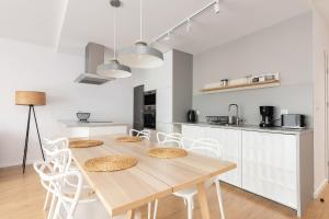 a kitchen and dining room with a wooden table and chairs at Luxury Apartment Nearto Old Town Vermelo in Krakow