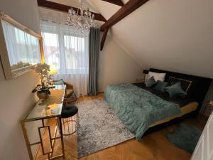 a bedroom with a green bed and a chandelier at Comfort Zone Ostróda Villa Apartment Duplex in Ostróda