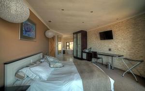 een slaapkamer met een groot wit bed en een bureau bij Beach Lodge in Swakopmund