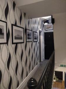 a hallway with a patterned wall with pictures on it at Seaview B&B in Harwich