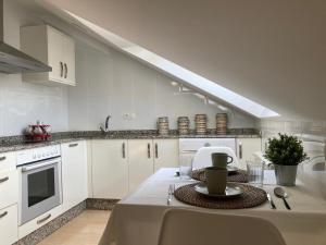 a kitchen with white cabinets and a table with a plate at O Pequeno Rincón in Allariz