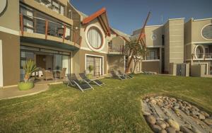 uma casa com um quintal com cadeiras em Beach Lodge em Swakopmund