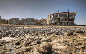 a large building sitting on a rocky beach at Beach Lodge in Swakopmund