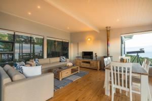 a living room with a couch and a table at Constantia Views Villa Wilderness in Wilderness