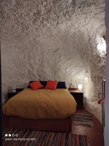 a bedroom with a bed in a stone wall at Cueva Albaicín Granada avec vue sur l'Alhambra in Granada