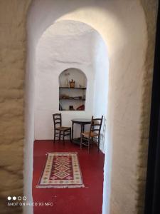 a dining room with a table and chairs and a rug at Cueva Albaicín Granada avec vue sur l'Alhambra in Granada