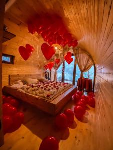 un dormitorio con corazones rojos colgando del techo en Woodhide - Cottages near Batumi, Georgia en Zeda Ch'khutunet'i