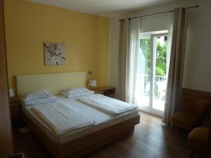 a bedroom with a bed and a sliding glass door at Hotel Zima in Merano