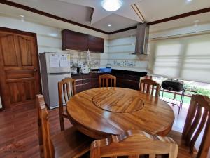 a kitchen with a wooden table and chairs in it at Sand-D House Pool Villa A7 at Rock Garden Beach Resort Rayong in Mae Pim