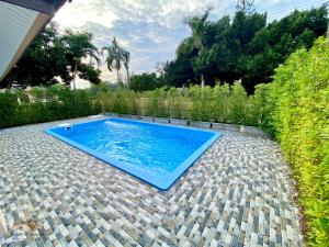 a blue swimming pool sitting on a brick patio at Sand-D House Pool Villa A7 at Rock Garden Beach Resort Rayong in Mae Pim