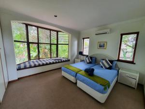 a bedroom with a large bed and two windows at Villa at Selborne Golf Estate in Pennington