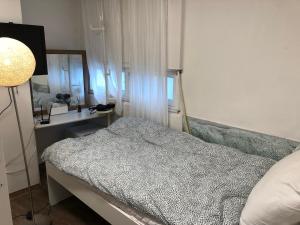 a bedroom with a bed and a lamp and a mirror at Hostel Metro in Seoul