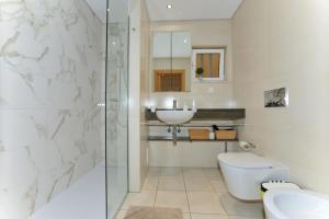 a bathroom with a toilet and a sink and a shower at Varandas D'Agua in Portimão