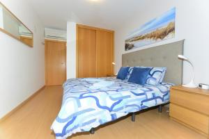a bedroom with a bed with a blue and white comforter at Varandas D'Agua in Portimão