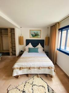 a bedroom with a large bed and a rug at Riad Al Madina in Essaouira