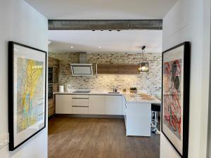 a kitchen with white cabinets and a brick wall at PUERTO BANUS Apartamento FANTASTICO in Marbella