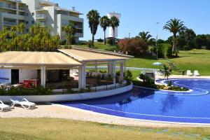 a swimming pool with a pavilion next to a resort at Tupi Nest in Alvor