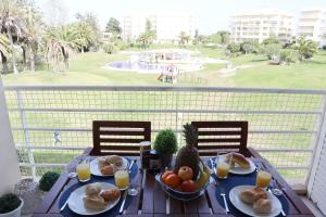 a table with food and fruit on a balcony with a view at Tupi Nest in Alvor