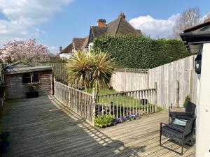 una terraza de madera con una valla y una silla en Beddington Park Lodge East, en Wallington