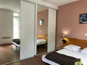 a bedroom with two beds and a mirror at Grand T3 centre Cauterets 6 à 8 pers. WIFI. Balcon in Cauterets