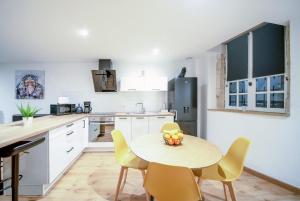 uma cozinha com uma mesa e cadeiras numa cozinha em Appartement POP au coeur du centre ville em Mâcon