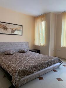 a bedroom with a bed with a brown comforter at Студио Бургас 2 in Burgas