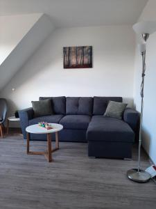 a living room with a blue couch and a table at Ferienwohnung Schloßstr. 8, Mirow in Mirow