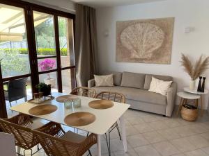a living room with a couch and a table and chairs at Appartamento Oliva mit Seeblick in Toscolano Maderno