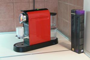 a red coffee maker on a counter next to a book at Kornelia Residence in Budapest