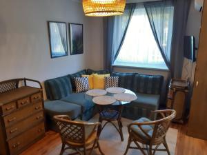 Una sala de estar con un sofá, una mesa y sillas. en Polanica Centrum, en Polanica-Zdrój