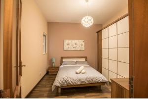 a small bedroom with a bed and a pendant light at Bugibba Square Seaview 3 Bedroom Apartment in St. Paul's Bay
