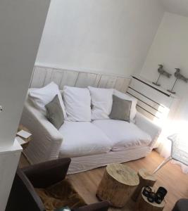 Domus Damme في دام: غرفة معيشة مع أريكة بيضاء وطاولة